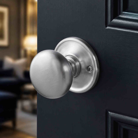 Close-up of a satin chrome cottage door knob with round backplate fitted to a dark panelled internal door.