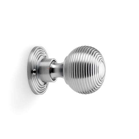 Side profile view of satin chrome reeded beehive rim mortice door knob with circular backplate.