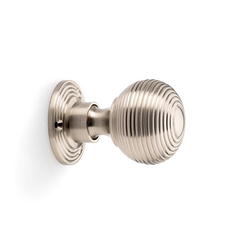 Side profile view of satin nickel reeded beehive rim mortice door knob with circular backplate.
