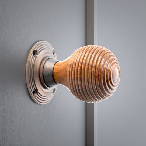 Rosewood beehive door knob fitted to a grey door with a matt antique backplate