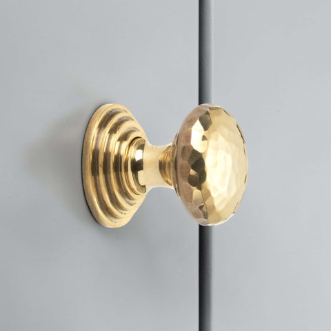 32mm solid aged brass hammered cupboard knob with stepped backplate fitted to grey cabinet door