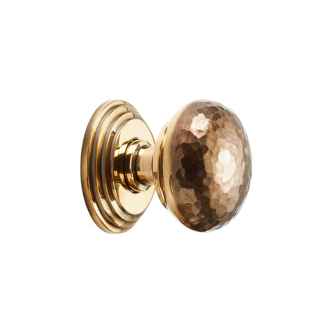 Side view of hammered solid brass mortice door knob on stepped backplate aged brass finish