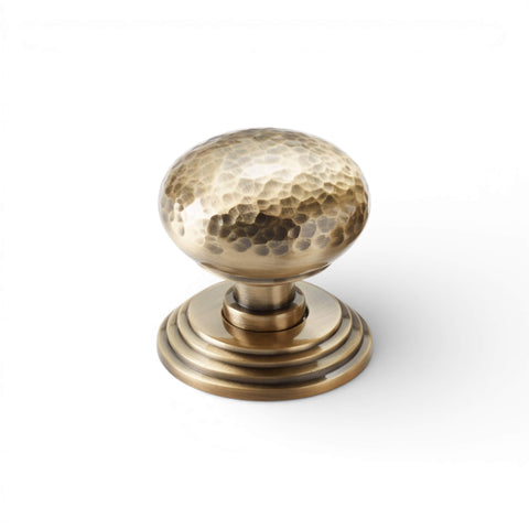 Hammered solid brass mortice door knob on stepped backplate in antique brass finish
