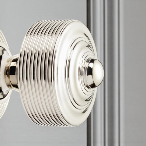Polished nickel reeded centre door knob fitted to a door, showing its reflective finish and reeded detailing.