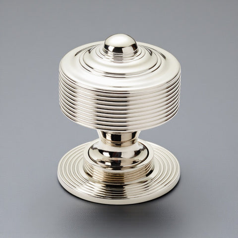 Solid brass reeded centre door knob in polished nickel finish displayed on a grey background.