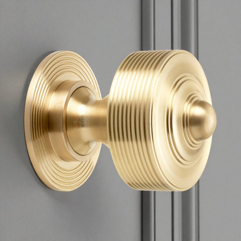 80mm solid brass reeded centre door knob in satin brass fitted to grey door