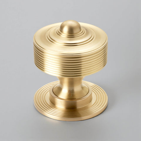 Front view of 80mm satin brass reeded centre door knob with backplate
