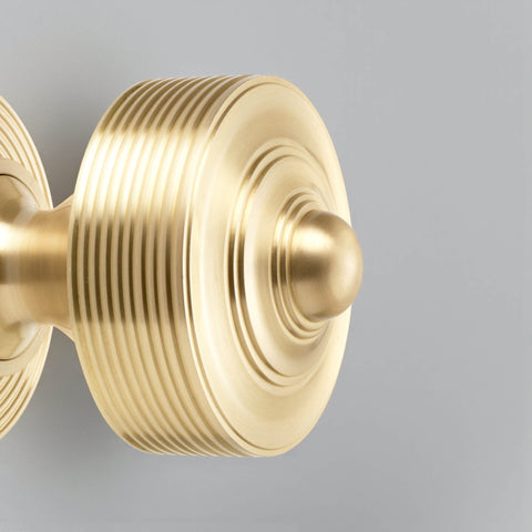 Close up detail of satin brass reeded centre door knob showing ribbed design