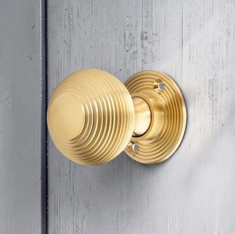 Satin brass beehive door knob fitted to painted wooden door