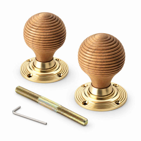 Pair of teak wood beehive door knobs with polished brass reeded backplates, threaded spindle and Allen key