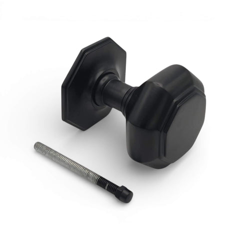 Very large powder coated black octagonal centre door knob with matching backplate and fixing bolt on white background
