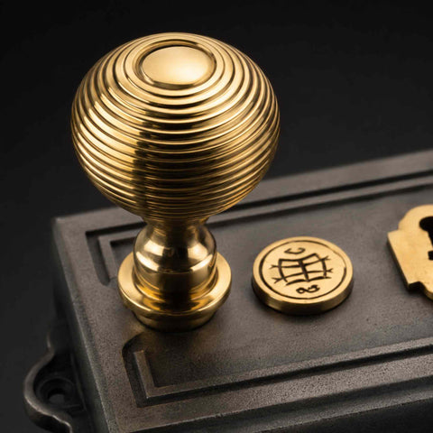 Detailed polished brass beehive door knob mounted on Victorian pewter Davenport rim lock showing concentric beehive design