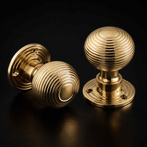 Polished brass beehive door knob pair showing traditional concentric beehive detailing and mirror-polished finish