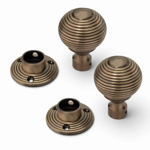 Antique brass beehive rim mortice door knobs shown disassembled with removable backplates, threaded spindle and Allen key.